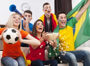 Friends of different nations celebrating goal of favourite team