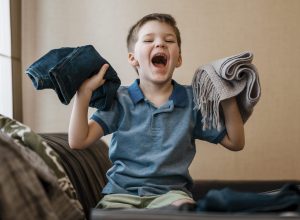 medium-shot-kid-holding-clothes