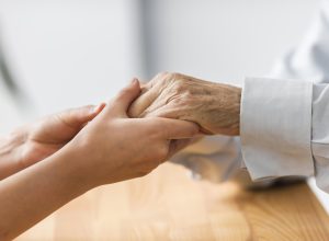 nurse-holding-senior-man-s-hands-comfort